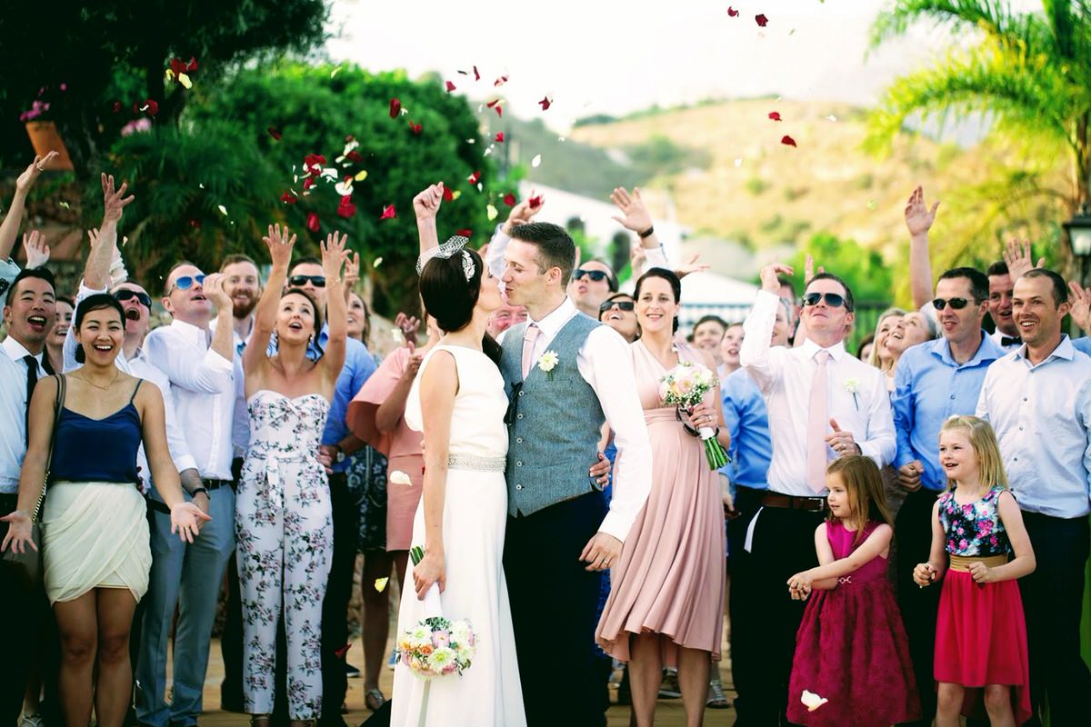 Family throwing petals to couple